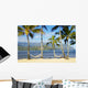Two hammocks hanging between palm trees on sandy tropical beach Wall Mural