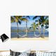 Two hammocks hanging between palm trees on sandy tropical beach Wall Mural