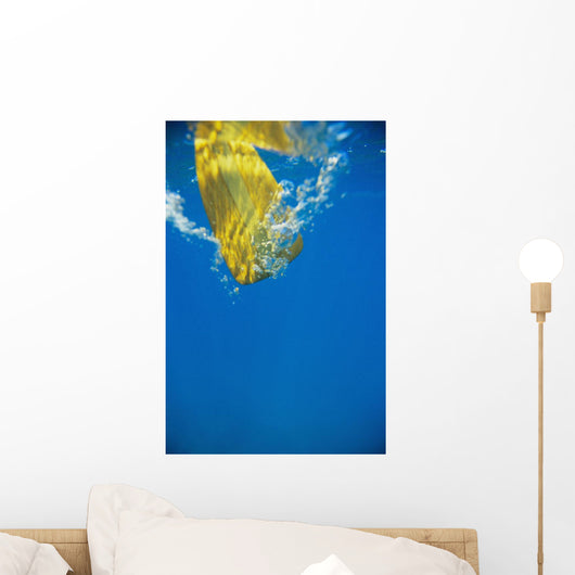 Underwater View Of Yellow Paddle Stroking Water, Creating Bubbles Wall Mural