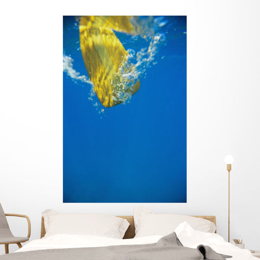 Underwater View Of Yellow Paddle Stroking Water, Creating Bubbles Wall Mural