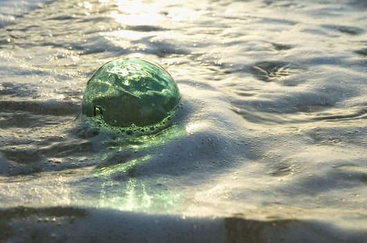 A Glass Fishing Ball Floats In Shallow Water, Bright Reflections Wall Mural