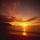 Calm Shoreline Ocean Waters With Orange Reflections From Sunset Wall Mural