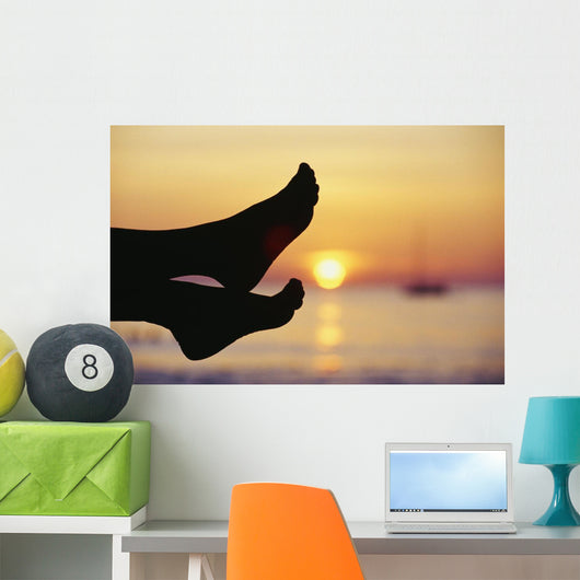 Silhouette Of Feet In Front Of A Sunset Over The Ocean Wall Mural