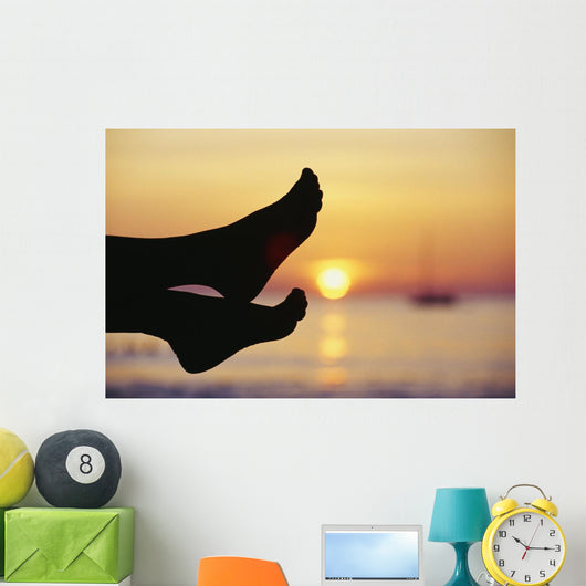 Silhouette Of Feet In Front Of A Sunset Over The Ocean Wall Mural