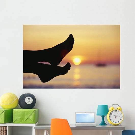 Silhouette Of Feet In Front Of A Sunset Over The Ocean Wall Mural