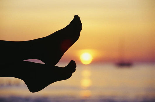 Silhouette Of Feet In Front Of A Sunset Over The Ocean Wall Mural