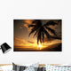 Distant View Of Couple Walking Along Beach At Sunset Wall Mural