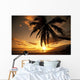 Distant View Of Couple Walking Along Beach At Sunset Wall Mural