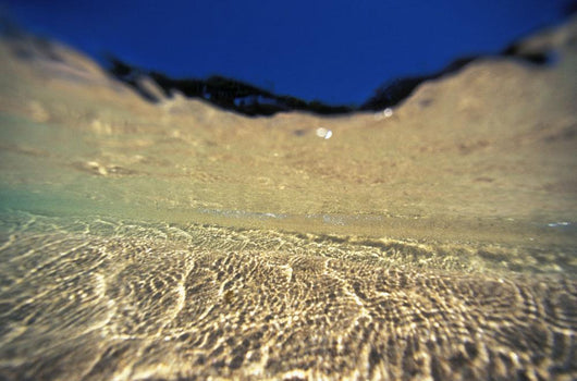Underwater Reflections Along Sandy Bottom, At Surface Blue Sky Visible Wall Mural