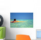 Woman Resting On Surfboard Looking Out On Clear Teal Water Wall Mural