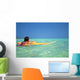 Woman Resting On Surfboard Looking Out On Clear Teal Water Wall Mural