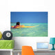 Woman Resting On Surfboard Looking Out On Clear Teal Water Wall Mural