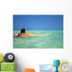 Woman Resting On Surfboard Looking Out On Clear Teal Water Wall Mural
