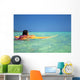 Woman Resting On Surfboard Looking Out On Clear Teal Water Wall Mural