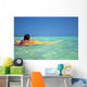 Woman Resting On Surfboard Looking Out On Clear Teal Water Wall Mural