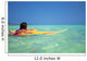 Woman Resting On Surfboard Looking Out On Clear Teal Water Wall Mural
