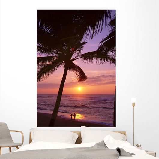 Couple In Distance On Beach Shoreline At Sunset Wall Mural