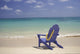 Plumeria Lei Hanging Over Blue Beach Chair Along Shoreline Wall Mural