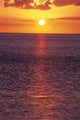 Sunset With Orange Sky Over Ocean Purple Surface With Reflections Wall Mural