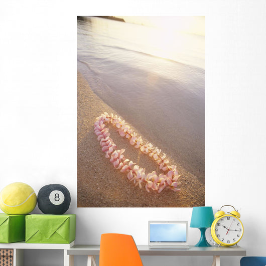 Pale Pink Plumeria Lei Along Shoreline Of Calm Water Wall Mural