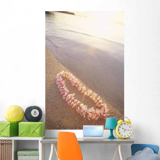 Pale Pink Plumeria Lei Along Shoreline Of Calm Water Wall Mural