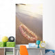 Pale Pink Plumeria Lei Along Shoreline Of Calm Water Wall Mural