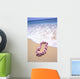 Close-Up Of Pink Lei In Sand On Beach, Foaming Shore Waters, Blue Sky Wall Mural