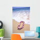 Close-Up Of Pink Lei In Sand On Beach, Foaming Shore Waters, Blue Sky Wall Mural