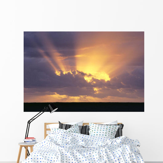 Sunrays Stream Out From Behind Clouds At Sunset, Over Dark Ocean Wall Mural