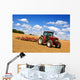 Tractor in plowed field Wall Mural