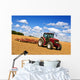 Tractor in plowed field Wall Mural