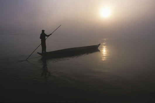 A Man Pushes His Dugout Canoe Along The Rapti River Wall Mural