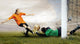 Shoot of football player and jump of goalkeeper on the field of Wall Mural