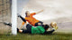 Shoot of football player and jump of goalkeeper on the field of Wall Mural