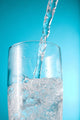 Stream Of Water Being Poured Into A Clear Glass Wall Mural