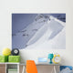 Skier On Crest Of Big Drop, Dwarfed By Mountain Wall Mural