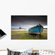A Weathered Boat Sitting On The Shore With Lindisfarne Castle Wall Mural