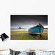 A Weathered Boat Sitting On The Shore With Lindisfarne Castle Wall Mural