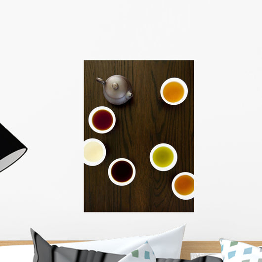 Teapot And Different Types Of Tea In Cups On A Wood Table Wall Mural