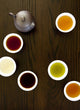 Teapot And Different Types Of Tea In Cups On A Wood Table Wall Mural