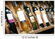 Closeup shot of wineshelf. Bottles lay over straw. Wall Mural