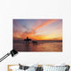 A Surfer Walks In Shallow Water With Her Dog At Sunset Wall Mural