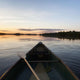 A Boat And Paddle On A Tranquil Lake At Sunset Wall Mural