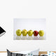 Four Yellow Apples With One Red Apple In A Row On A Reflective Surface Wall Mural