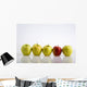 Four Yellow Apples With One Red Apple In A Row On A Reflective Surface Wall Mural