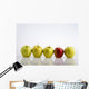 Four Yellow Apples With One Red Apple In A Row On A Reflective Surface Wall Mural