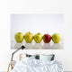 Four Yellow Apples With One Red Apple In A Row On A Reflective Surface Wall Mural