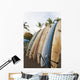 Surfboards Standing Up Against A Rack On The Beach Wall Mural