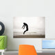 An Individual Wearing A Wet Suit Jumping In Mid-Air On A Beach Wall Mural