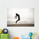 An Individual Wearing A Wet Suit Jumping In Mid-Air On A Beach Wall Mural